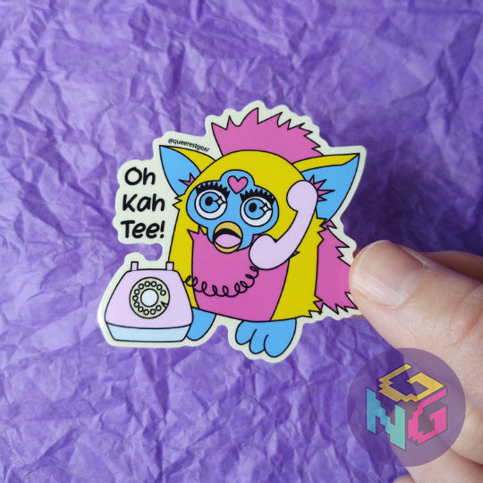 pansexual furby sticker talking on the phone held in front of a purple background