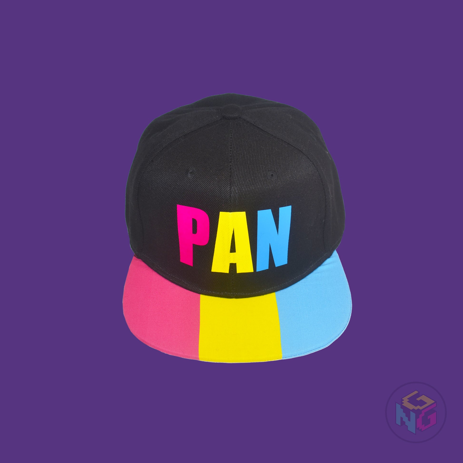 Black flat bill snapback hat. The brim has the pansexual pride flag on both sides and the front of the hat has the word “PAN” in pink, yellow, and blue letters. Front top view