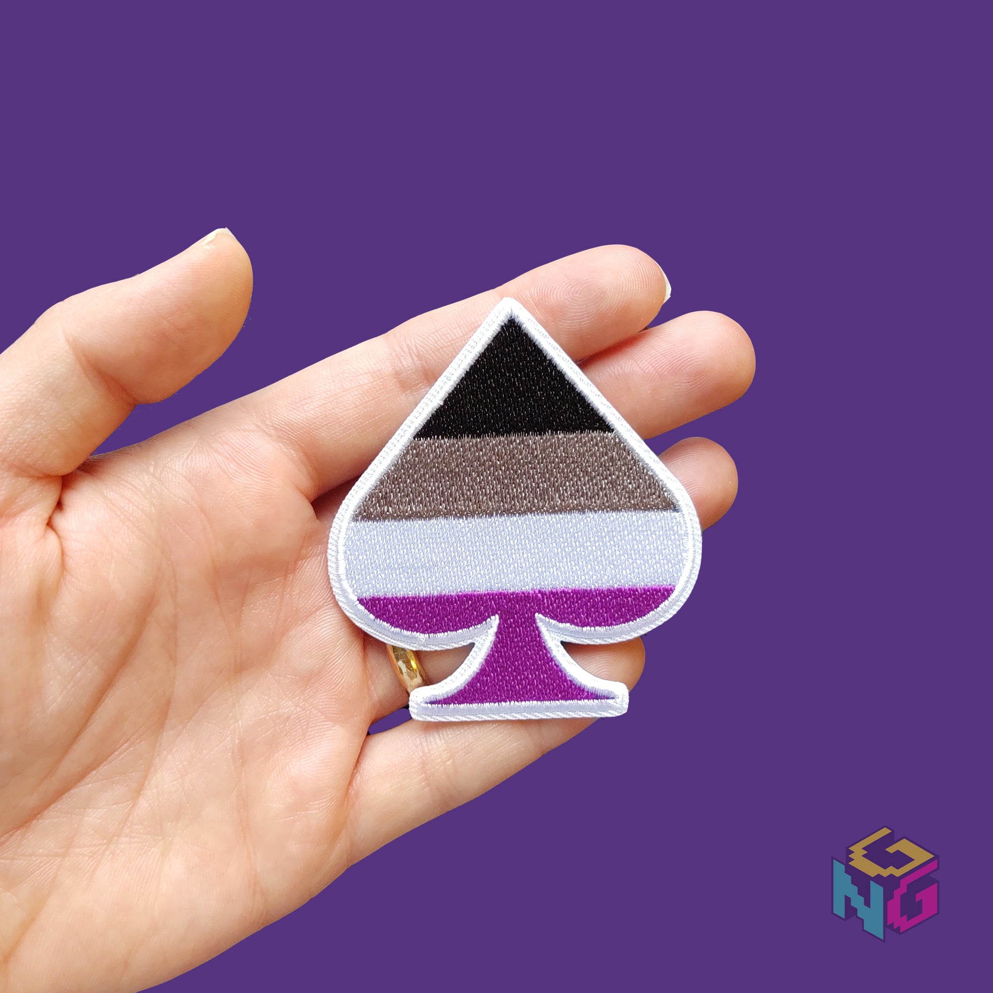 asexual embroidered patch held in a hand for scale in front of a purple background