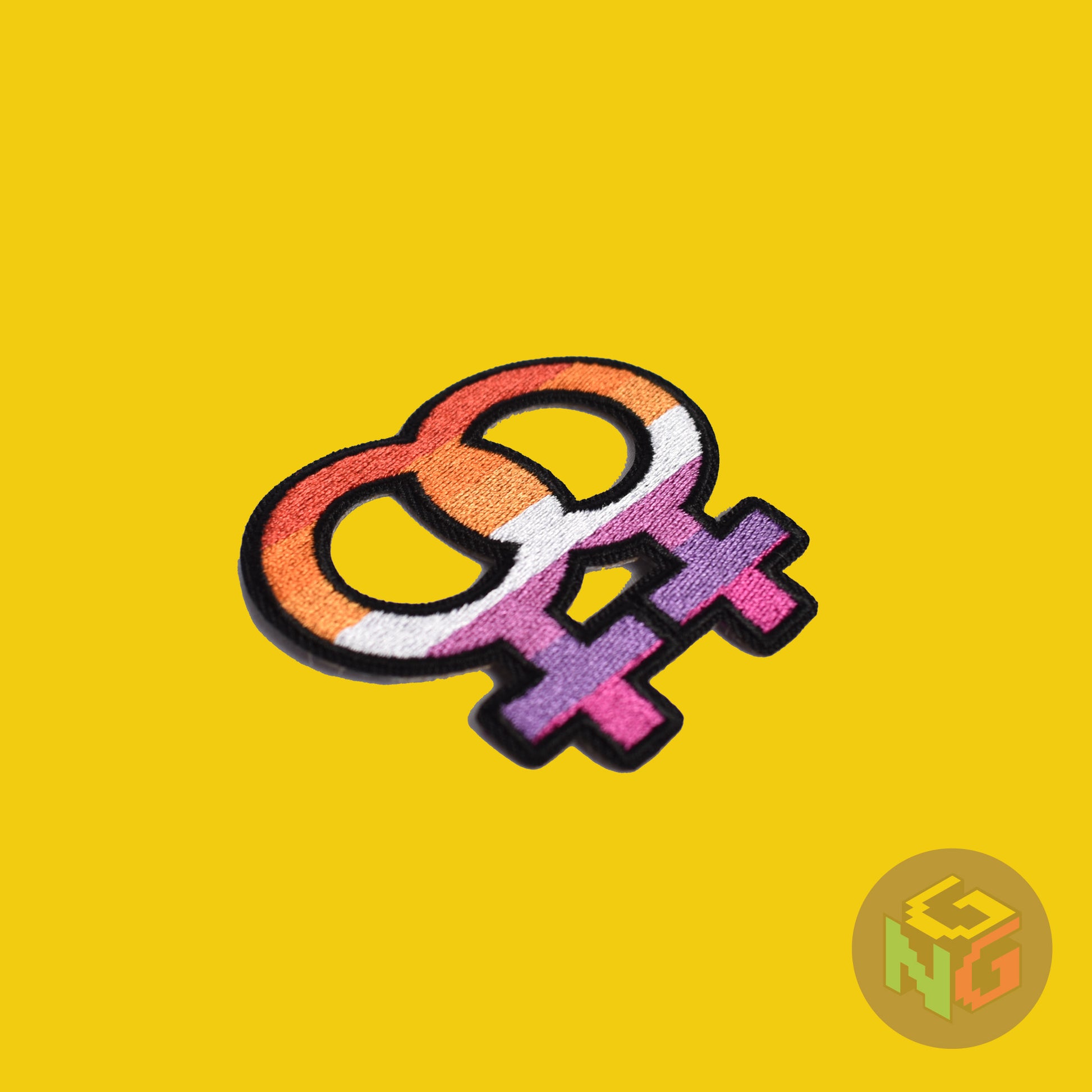 lesbian iron on patch lying on an angle against a yellow background