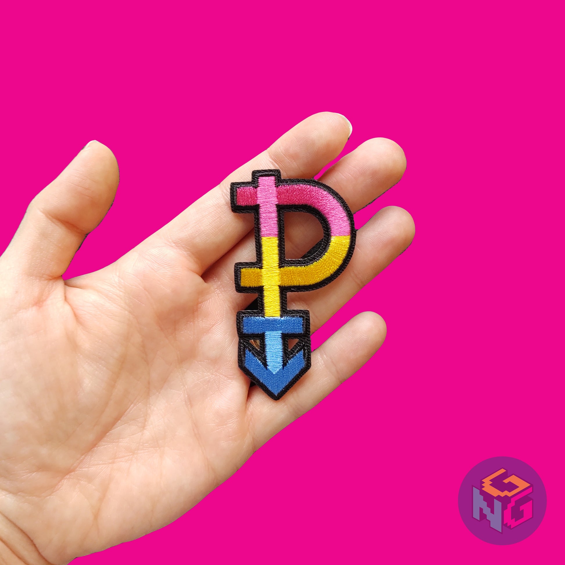 embroidered pansexual patch held in hand in front of hot pink background