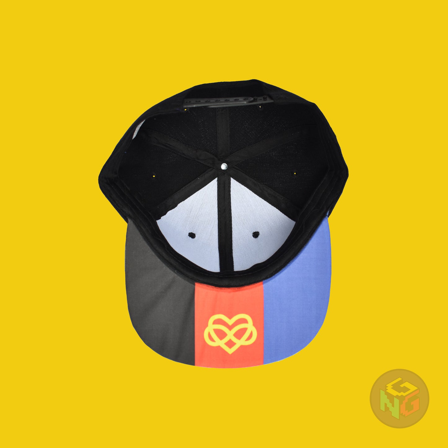 Black flat bill snapback hat. The brim has the polyamory pride flag with the heart infinity symbol on both sides and the front of the hat has the word “POLYAM” in red, yellow, and blue letters. Underside view