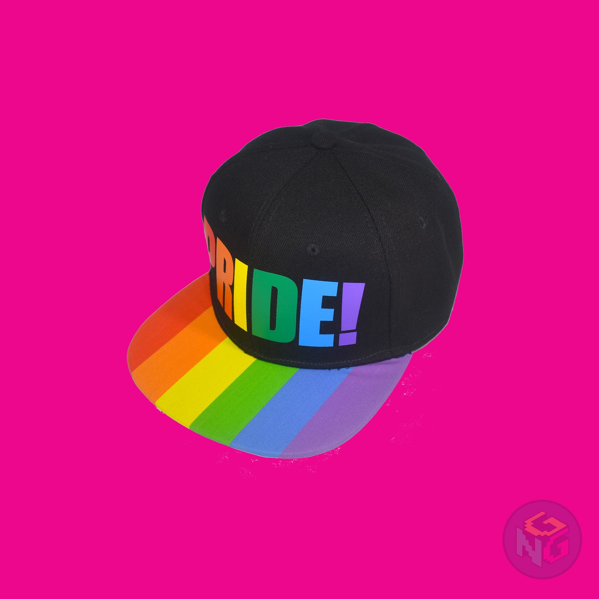 Black flat bill snapback hat. The brim has the rainbow pride flag on both sides and the front of the hat has the word “PRIDE!” in rainbow letters. Front left view