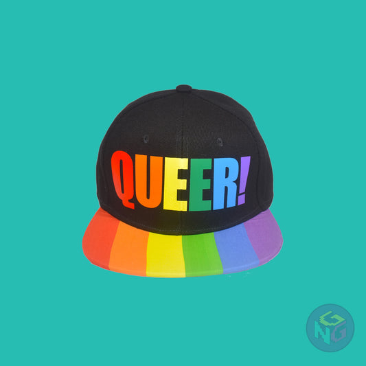 Black flat bill snapback hat. The brim has the rainbow pride flag on both sides and the front of the hat has the word “QUEER!” in rainbow letters. Front view
