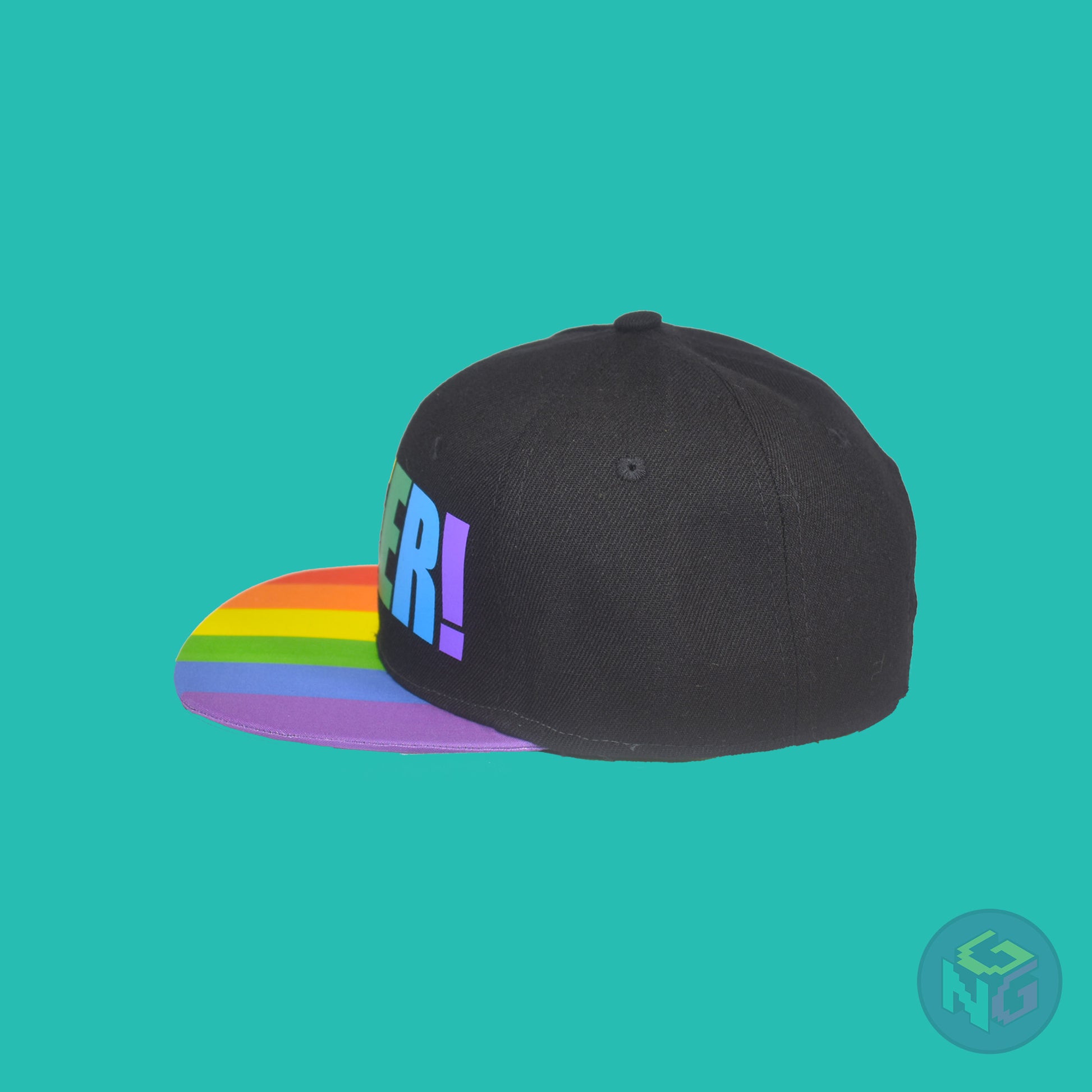 Black flat bill snapback hat. The brim has the rainbow pride flag on both sides and the front of the hat has the word “QUEER!” in rainbow letters. Left view