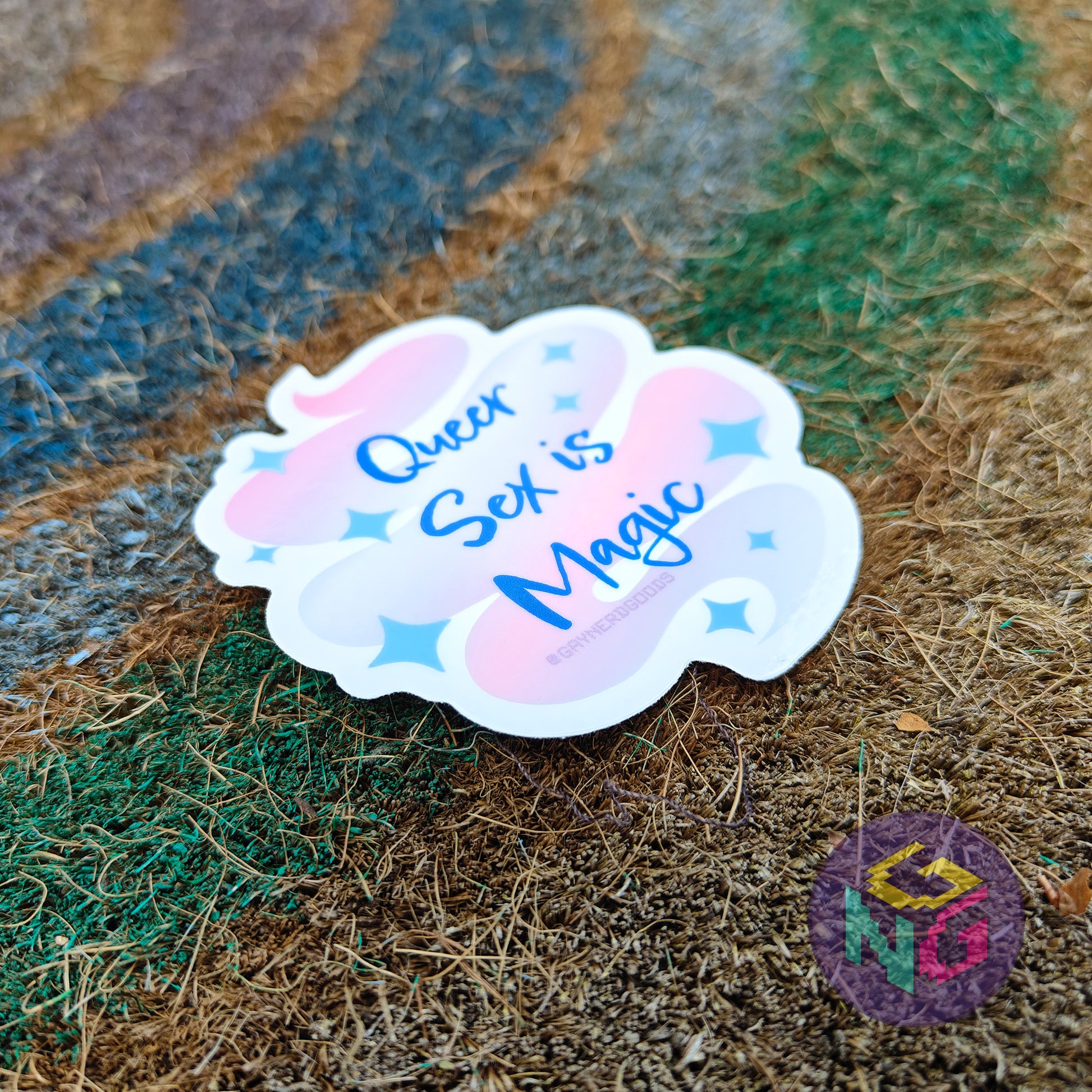 blue sparkle gay pride queer sex is magic waterproof sticker laying at an angle on a textured background