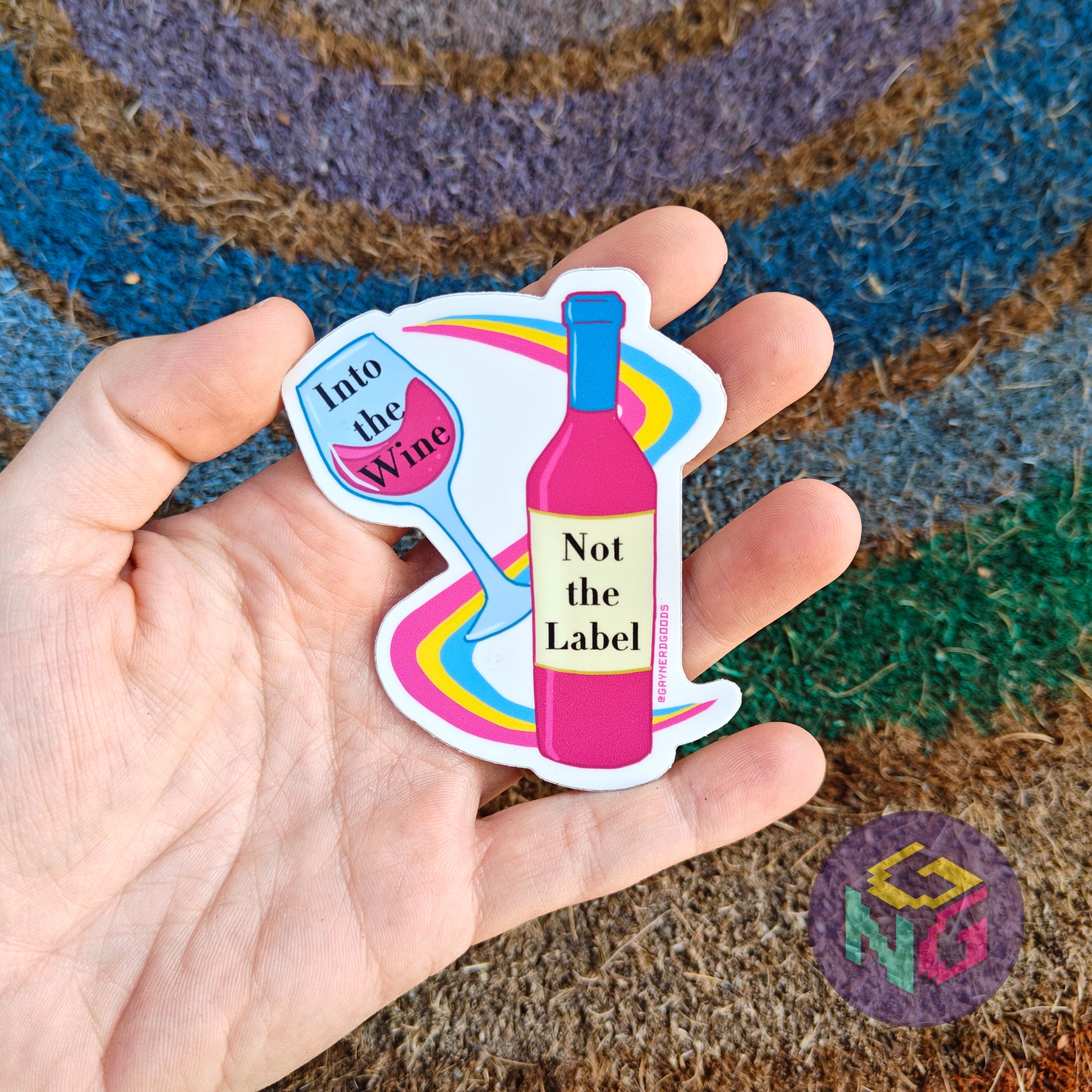 into the wine not the label pansexual pride vinyl sticker held in front of a rainbow welcome mat