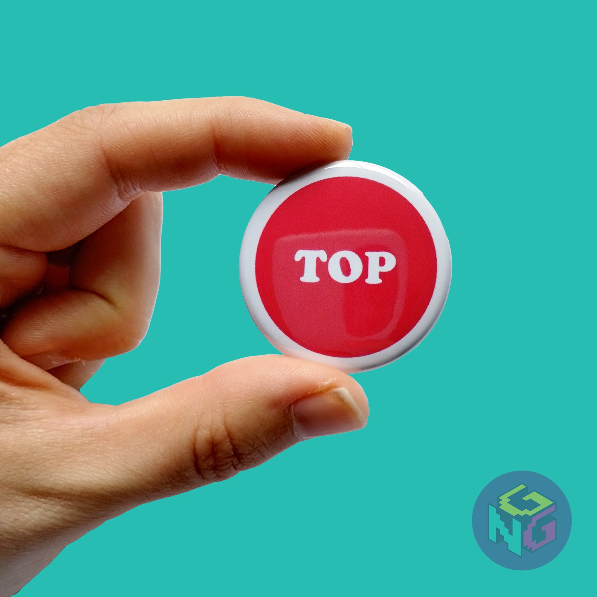 red top button held in hand on mint green background