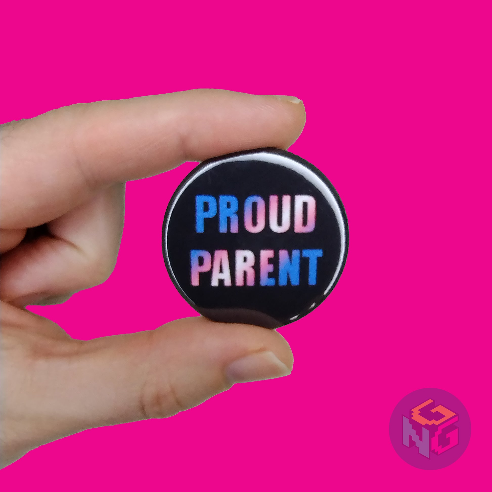 1.5" small proud parent pin held in a hand in front of a pink background