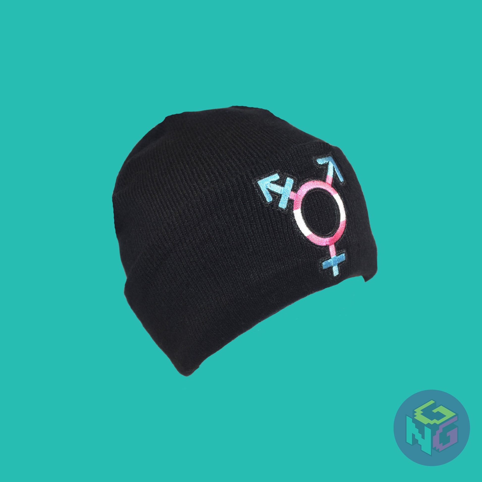 Black knit fabric beanie with the transgender symbol in blue, pink, and white on the front. It is stretched and seen in 3/4 view on a mint green background