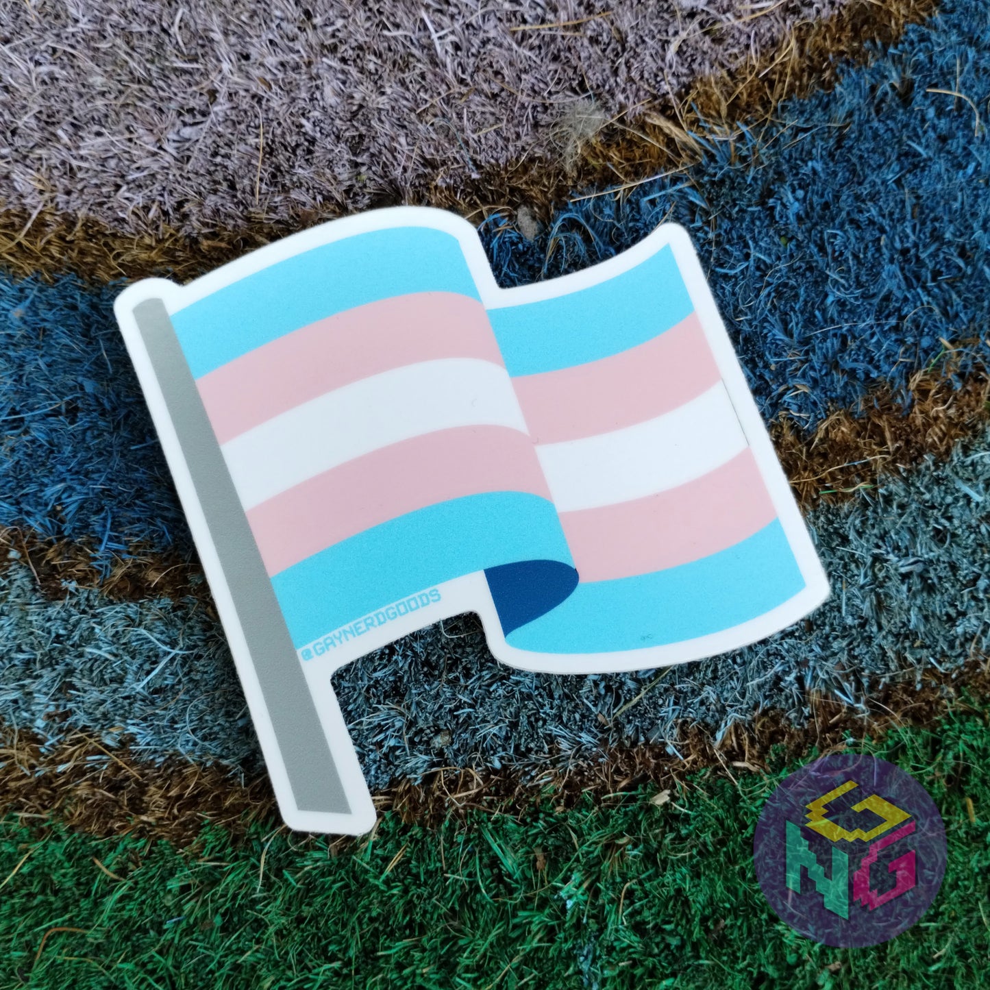transgender flag sticker lying flat on rainbow welcome mat