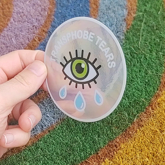 video of transphobe tears sticker being flashed in front of rainbow welcome mat