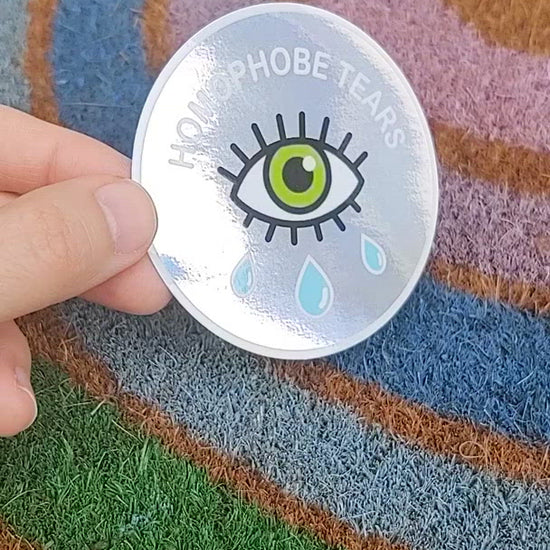 video of homophobe tears holographic sticker in front of rainbow background