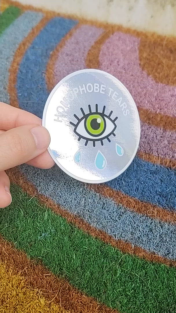 video of homophobe tears holographic sticker in front of rainbow background
