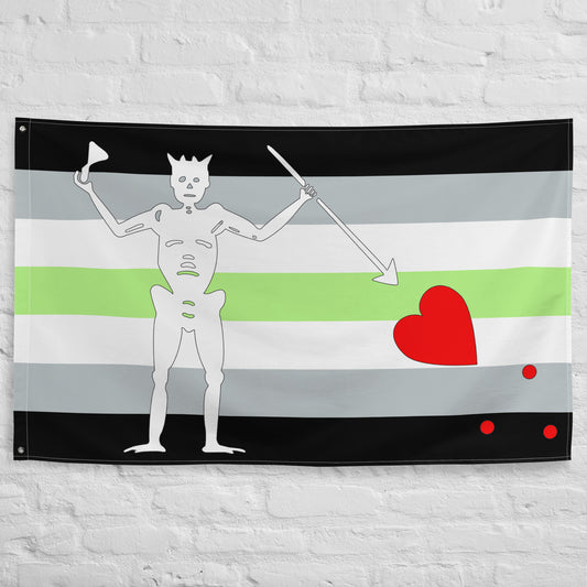 the agender flag with stripes of black, grey, white, and green and blackbeard's symbol hung on a white brick wall 