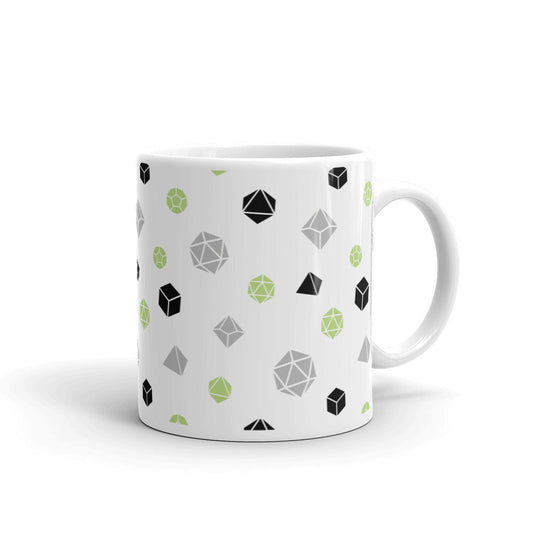 white mug on a white background with handle facing right. It has an all-over print of polyhedral d&d dice in the agender colors of green, grey, and black