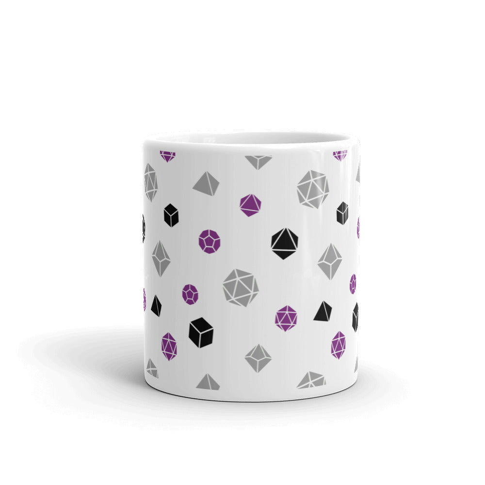 white mug on a white background with handle facing back. It has an all-over print of polyhedral d&d dice in the asexual colors of purple, grey, and black