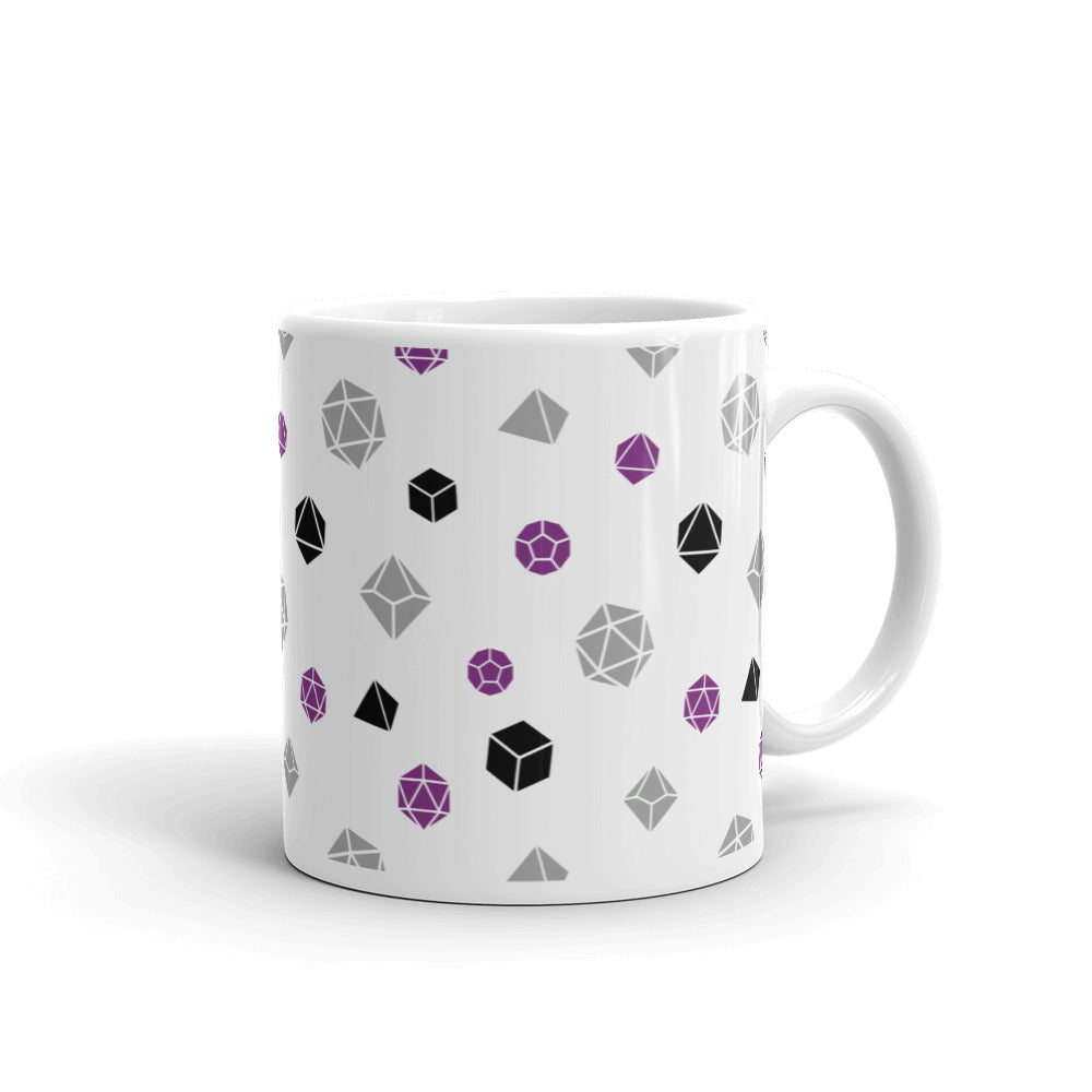 white mug on a white background with handle facing right. It has an all-over print of polyhedral d&d dice in the asexual colors of purple, grey, and black