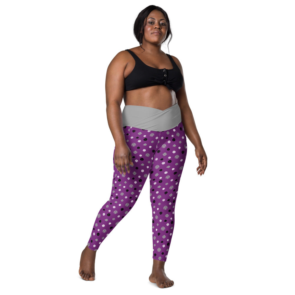 front view of dark-skinned female-presenting plus size model wearing asexual dice leggings and a black sports bra. This view shows off the grey crossover high-rise waistband