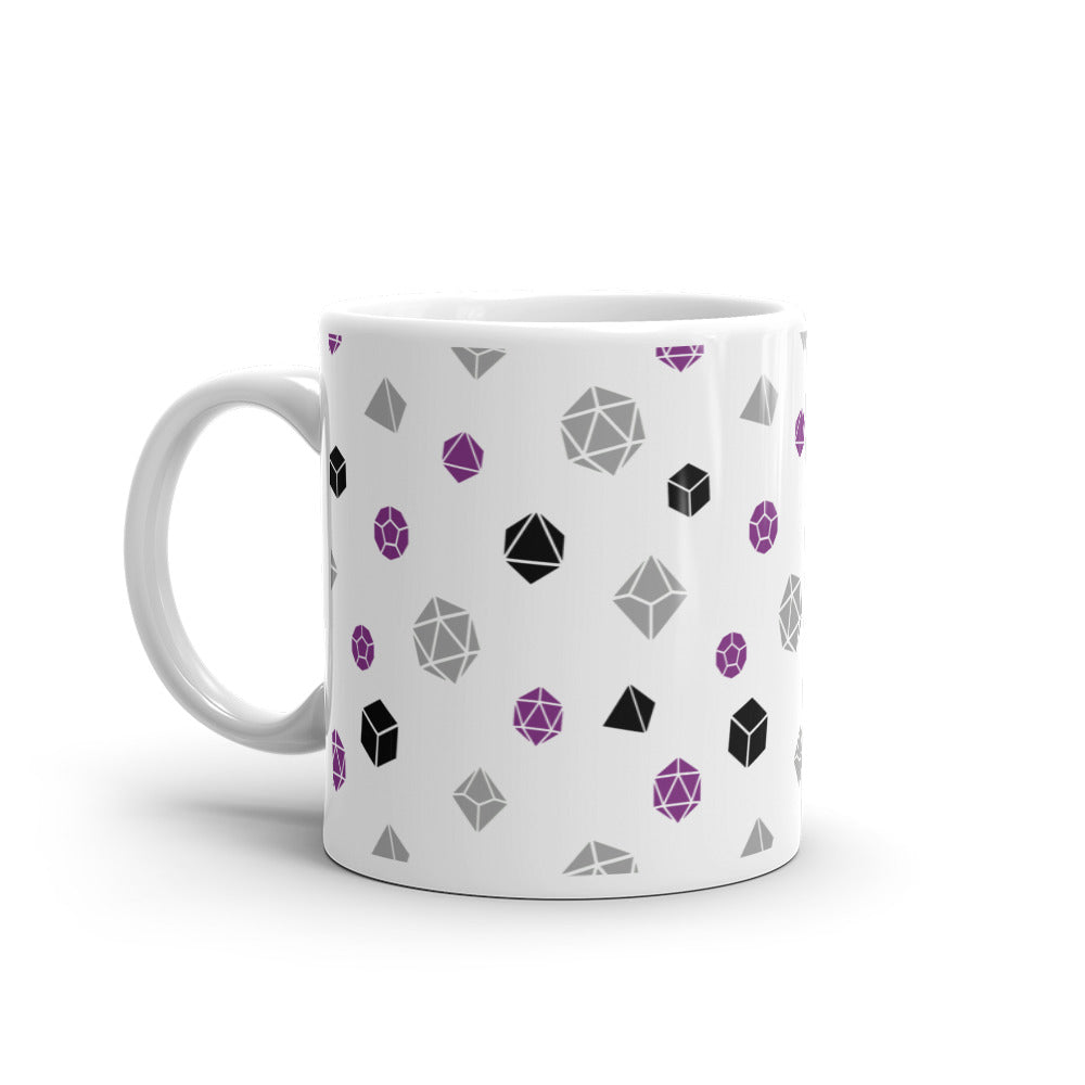 white mug on a white background with handle facing left. It has an all-over print of polyhedral d&d dice in the asexual colors of purple, grey, and black