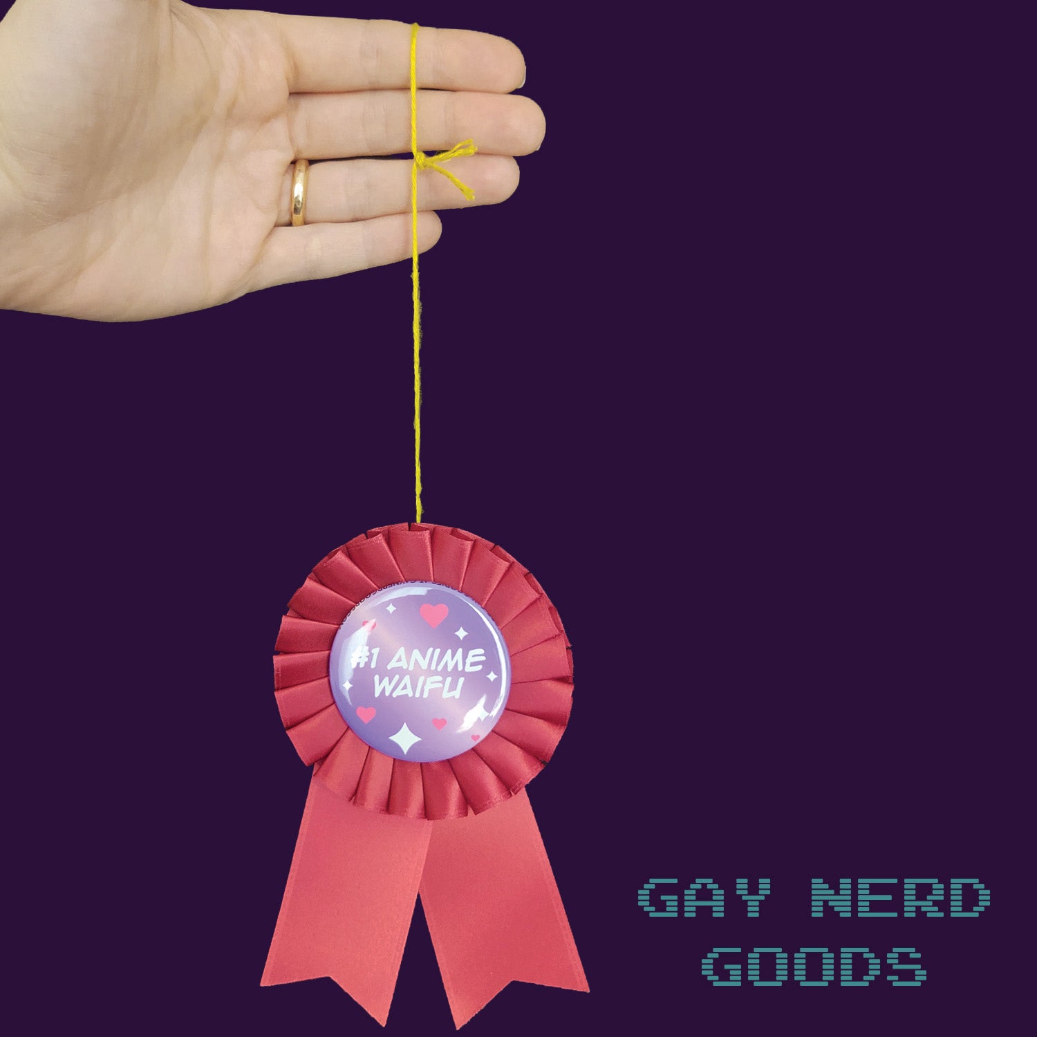 hand holding up the #1 anime waifu award ribbon by the thread against a dark purple background