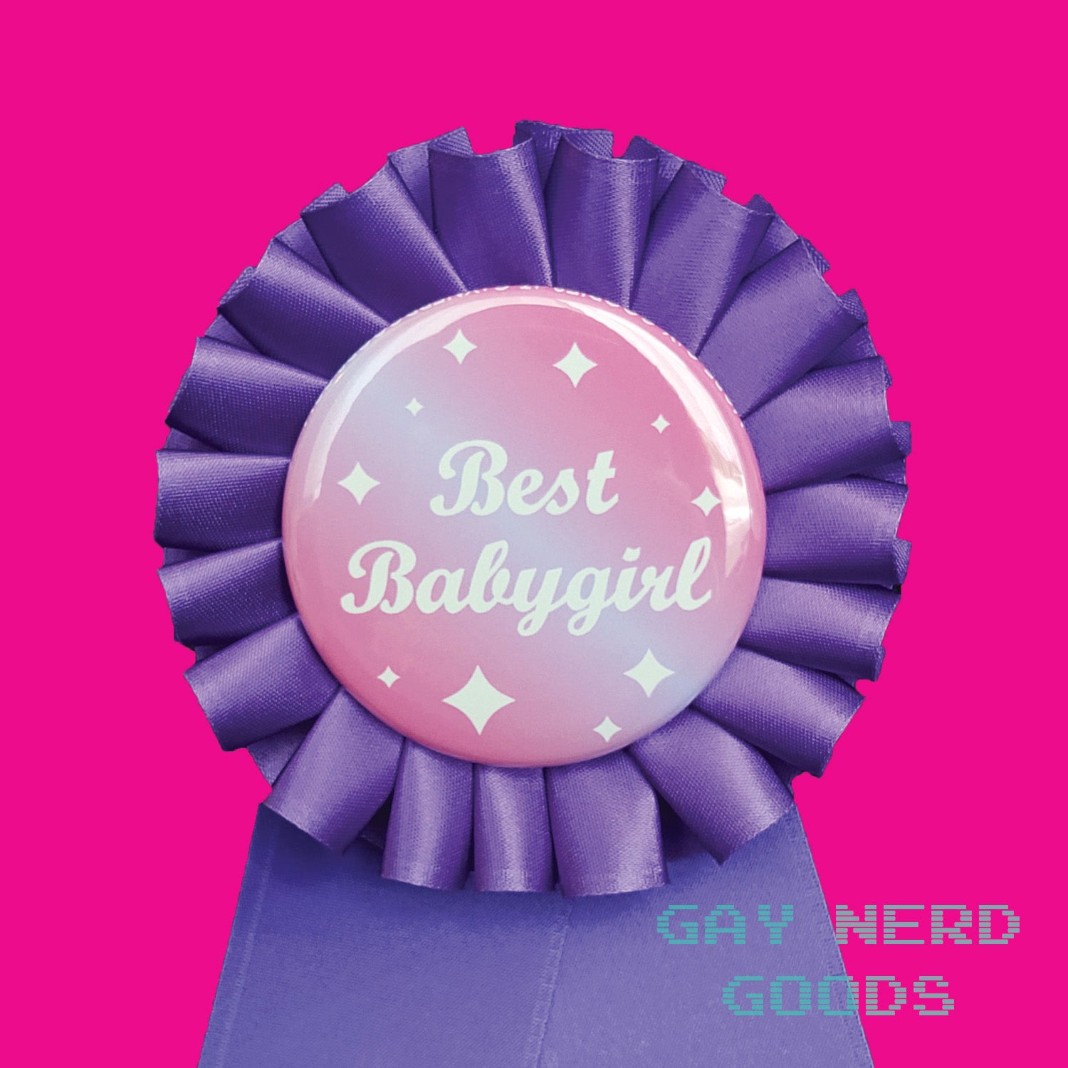 close up detail shot of the "best babygirl" award rosette. The text is white cursive with white sparkles on a pink and purple gradient background. The satin ribbon is purple