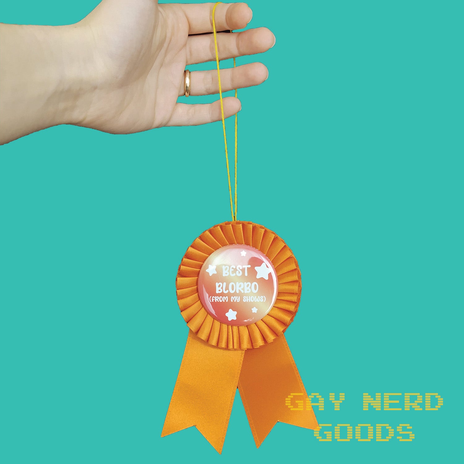 best blorbo award ribbon hanging by a yellow thread held in a hand