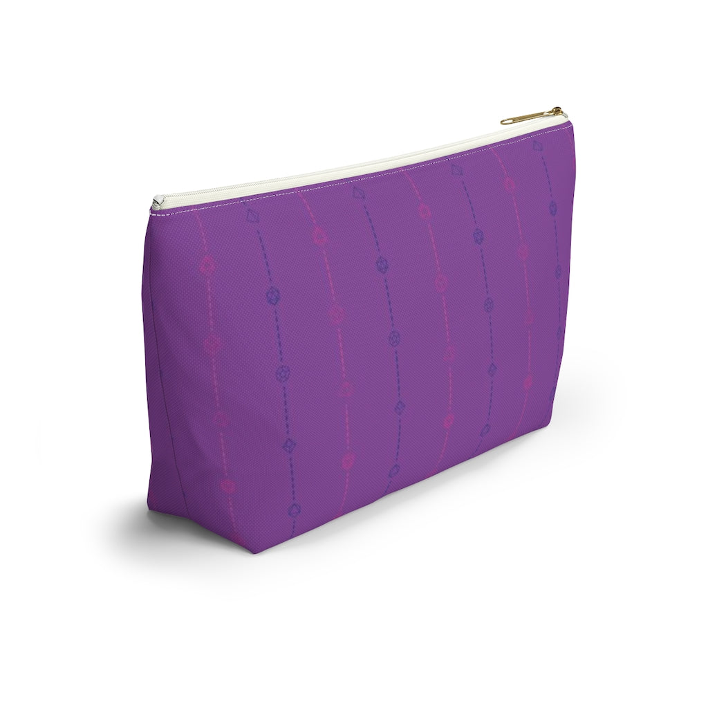 the large bisexual dice t-bottom pouch in side view on a white background. it's purple with pink and blue stripes of dashed lines and polyhedral dice and a gold zipper pull