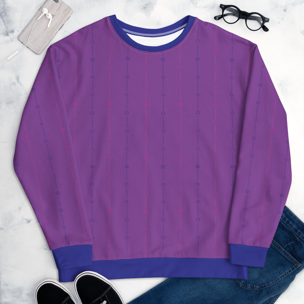 The bisexual pride sweater laying flat, surrounded by clothes, a phone, and glasses. the sweater is purple and has stripes of dashed lines and polyhedral dnd dice in pink and blue. The cuffs, collar, and waistband are blue
