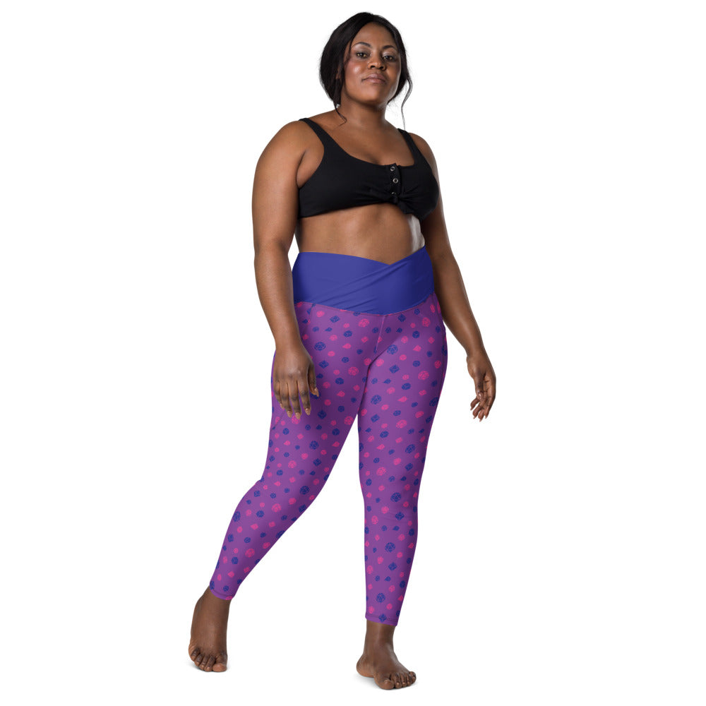 front view of dark-skinned female-presenting plus size model wearing the bisexual dice leggings and a black sports bra. This view shows off the blue crossover high-rise waistband