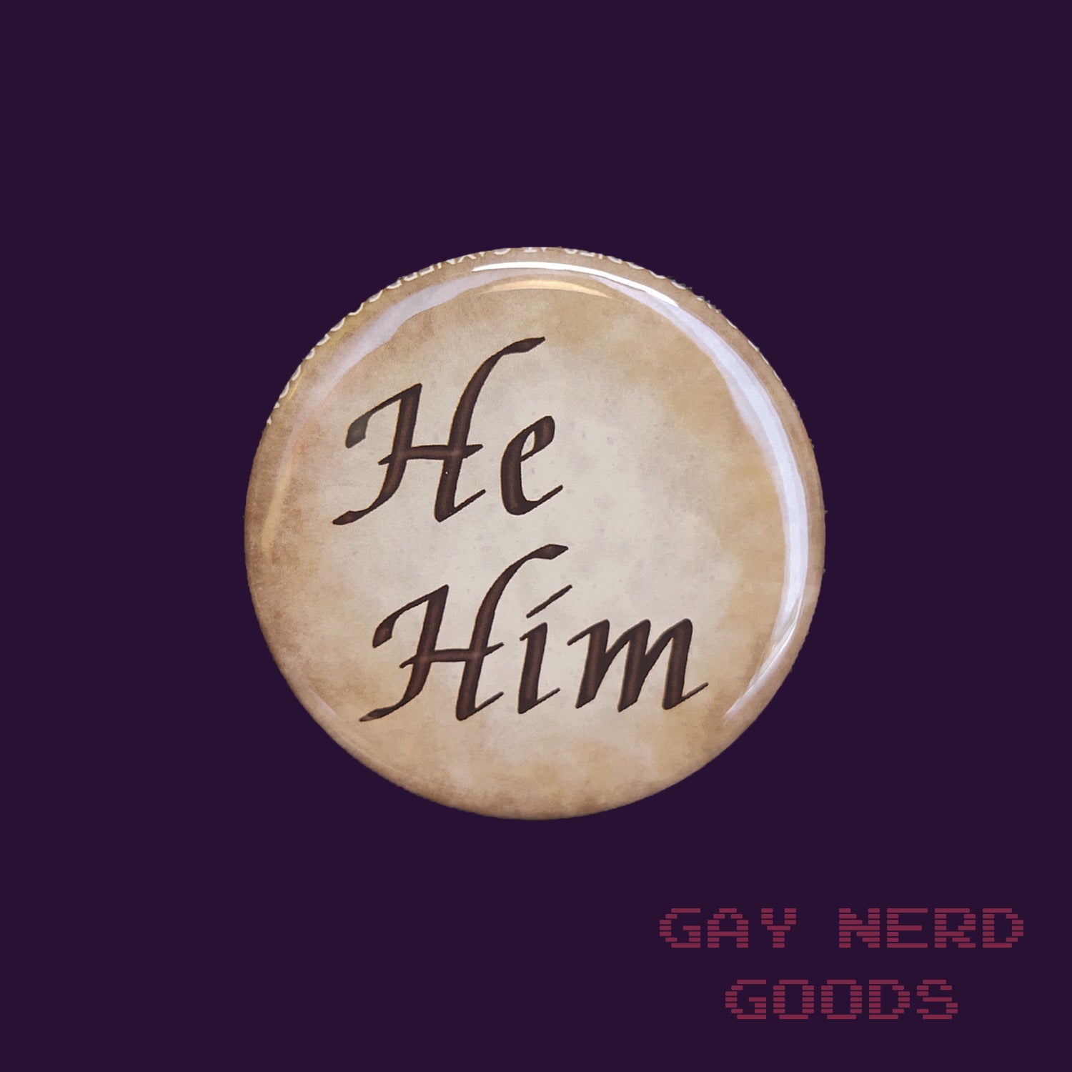 he him large calligraphy pronoun button on a dark purple background
