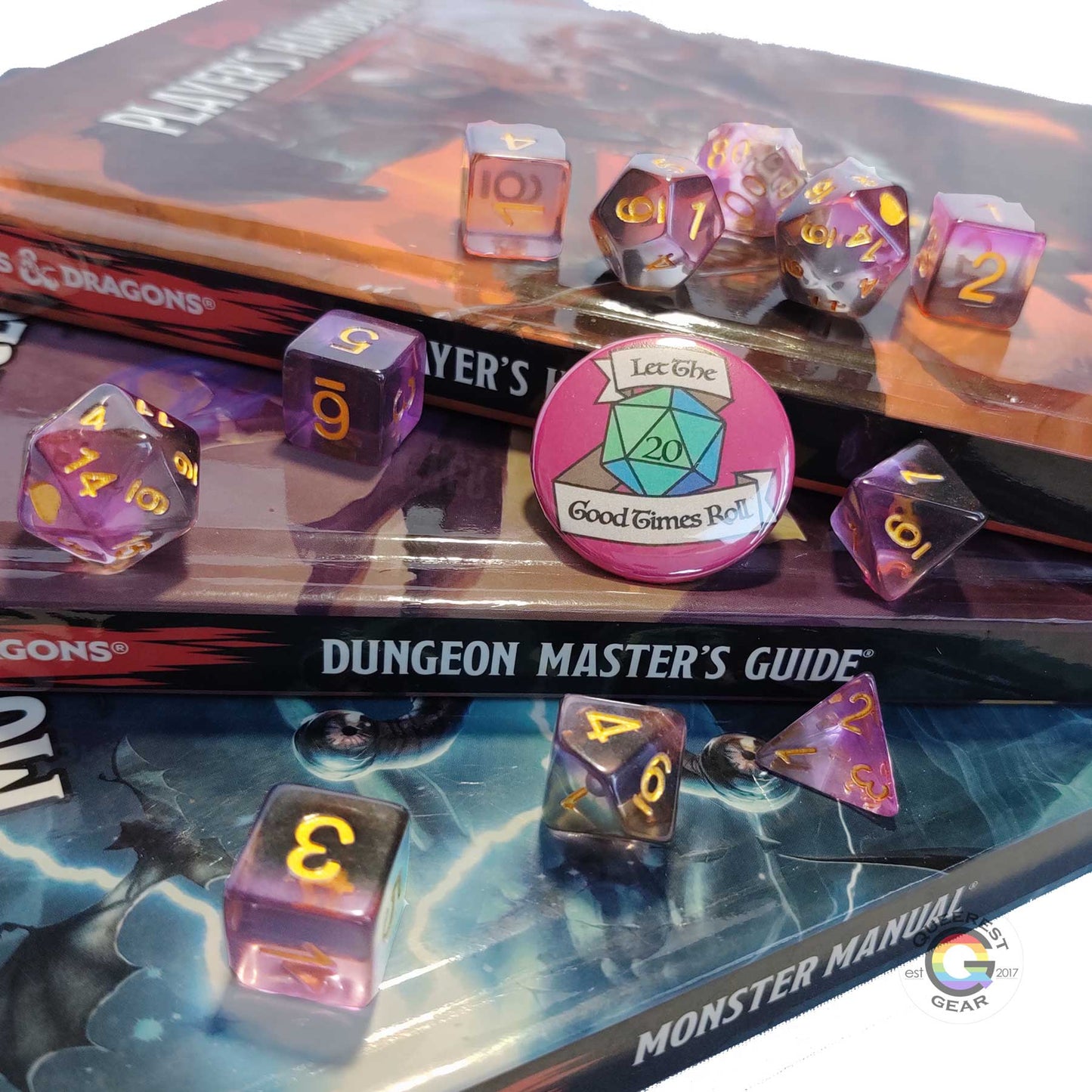 11 piece set of polyhedral dice scattered on a a stack of d&d books. They are transparent and colored in the stripes of the asexual flag with gold ink