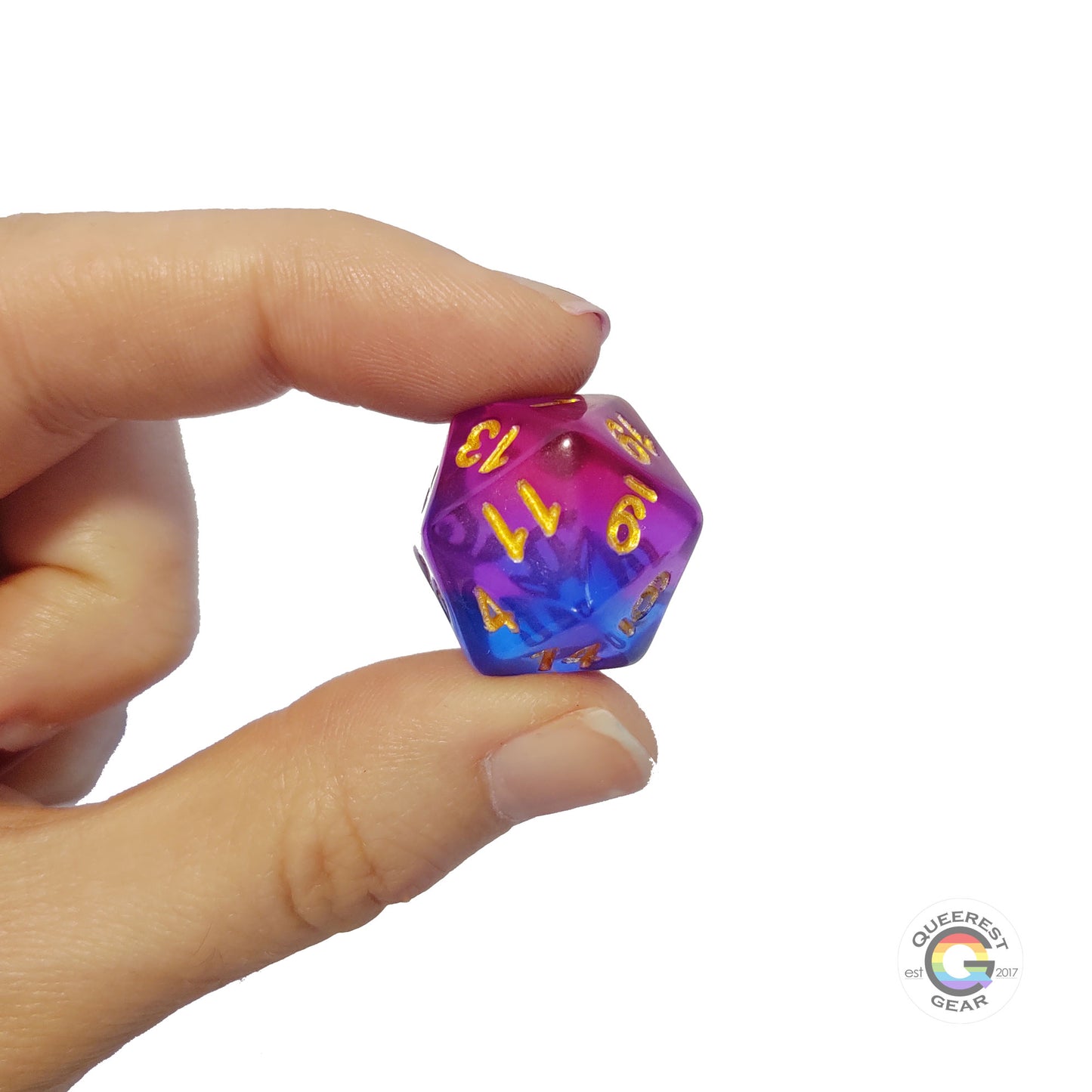 A hand holding up the bisexual d20 to show off the color and transparency