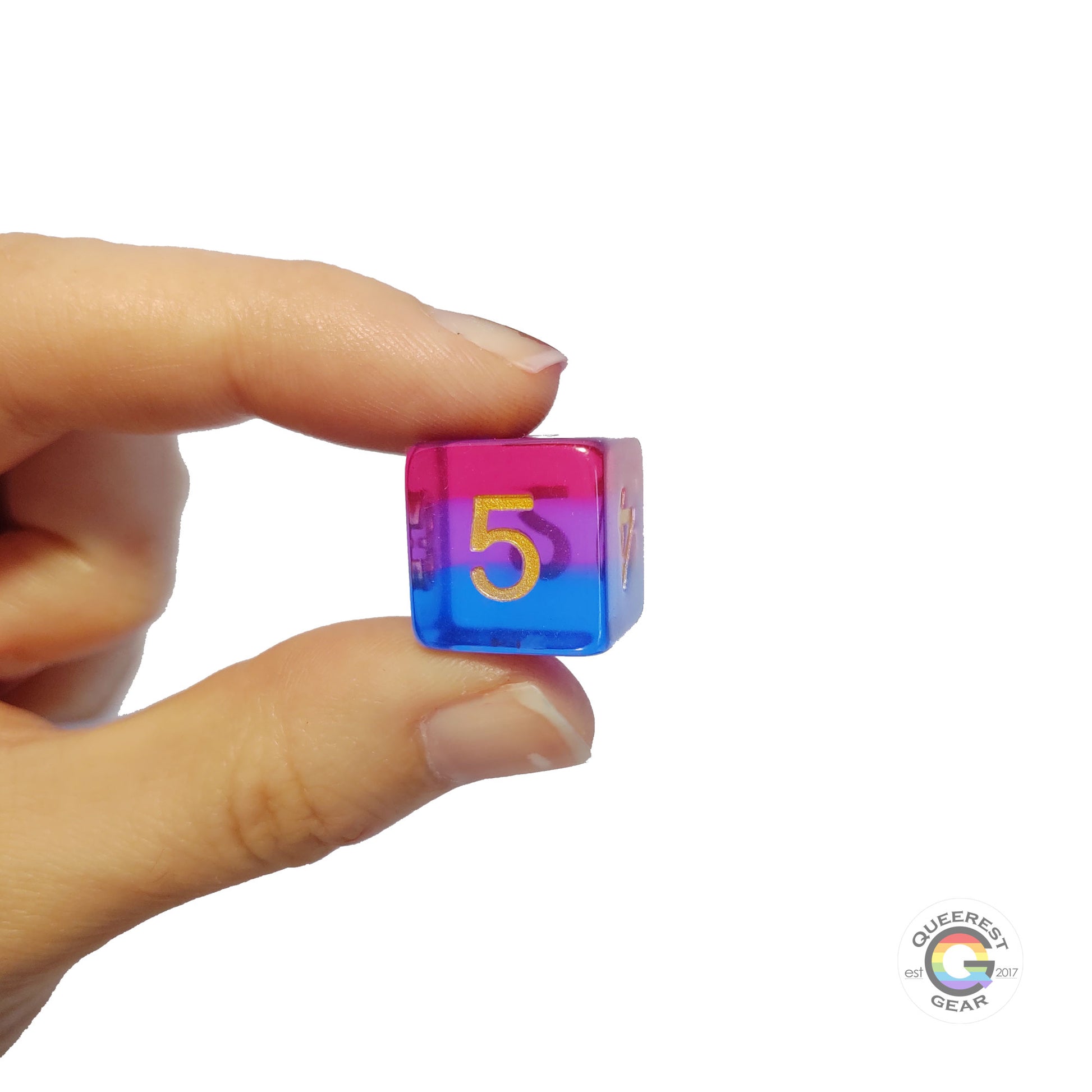 A hand holding up the bisexual d6 to show off the color and transparency