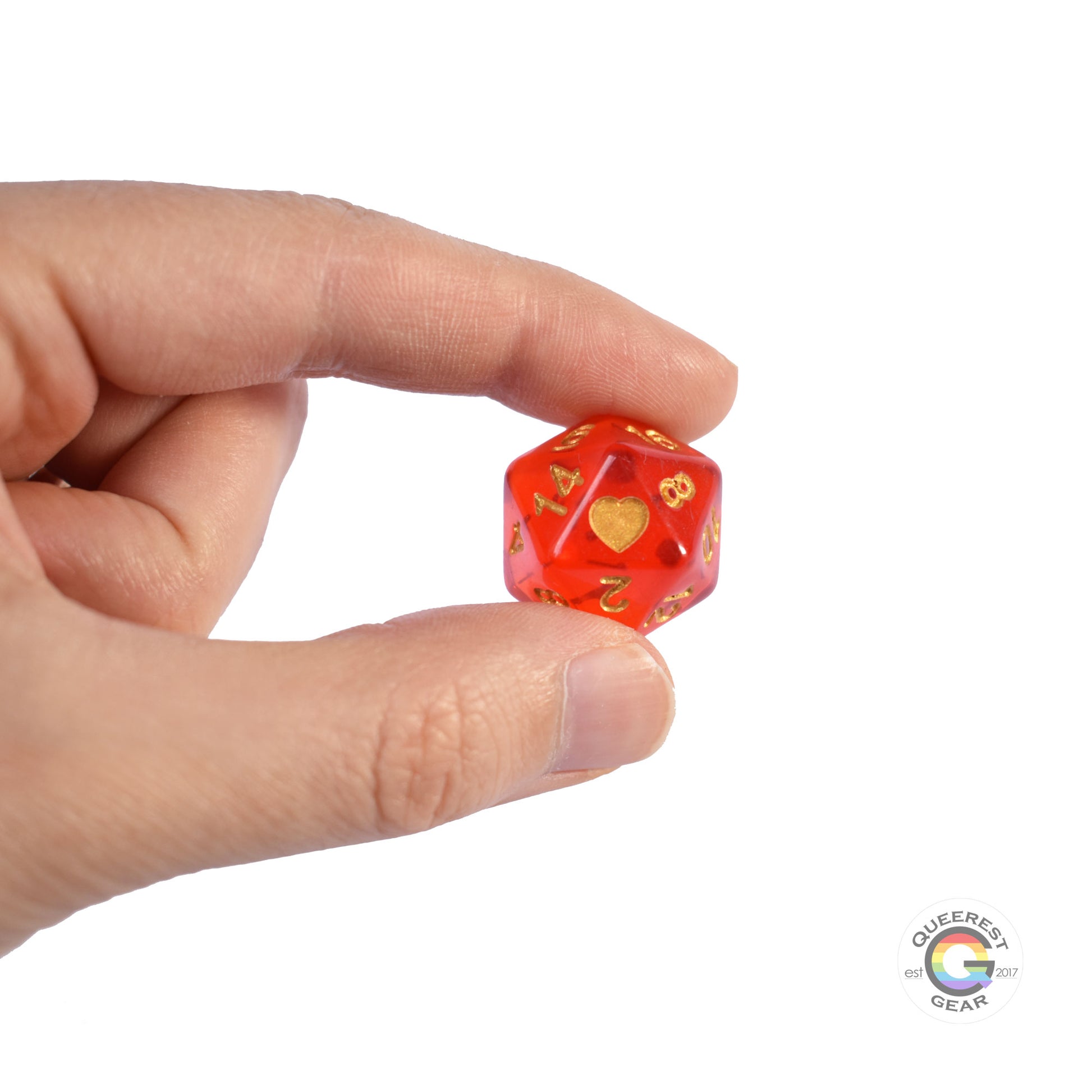 A hand holding up the lesbian d20 to show off the color, heart, and transparency