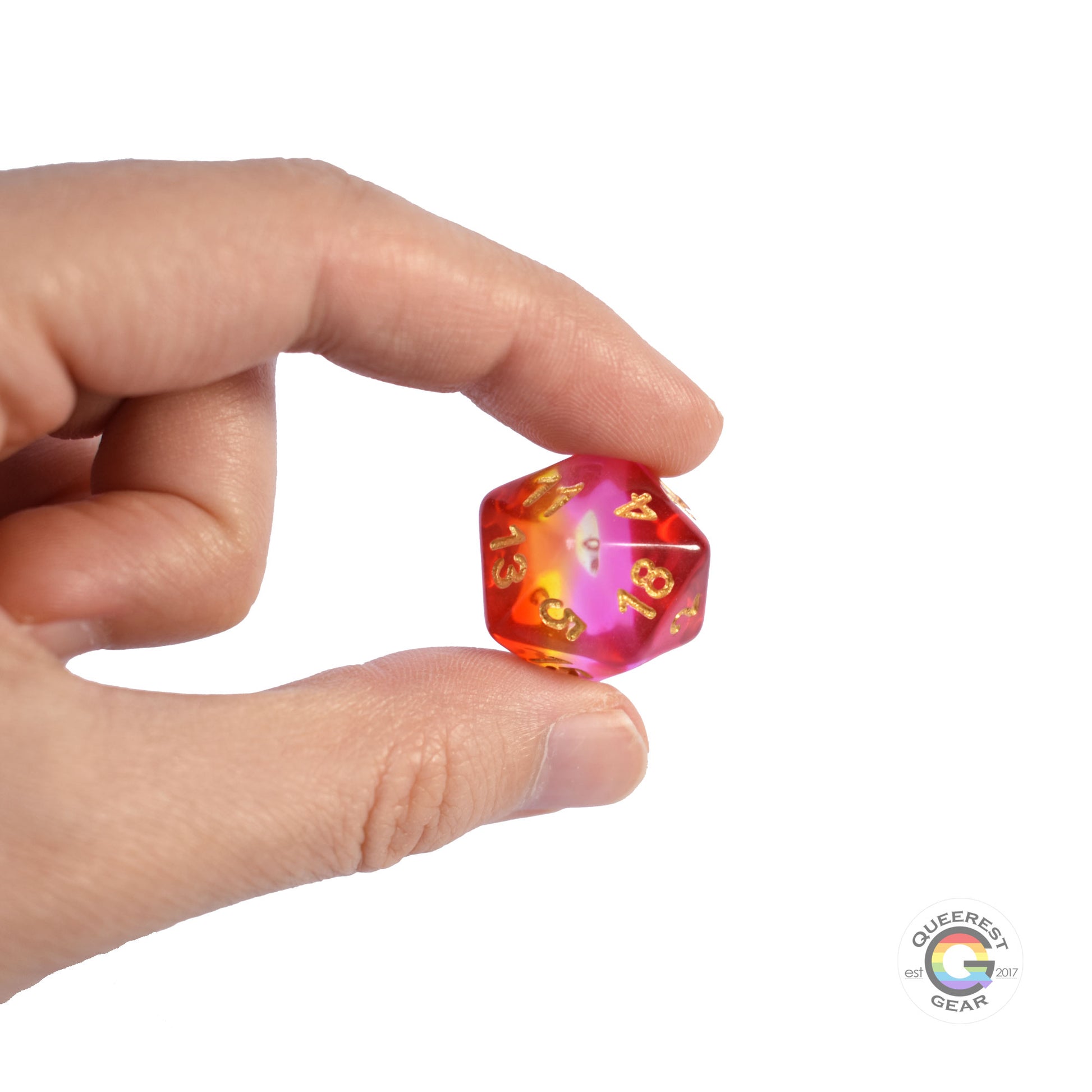 A hand holding up the lesbian d20 to show off the color and transparency