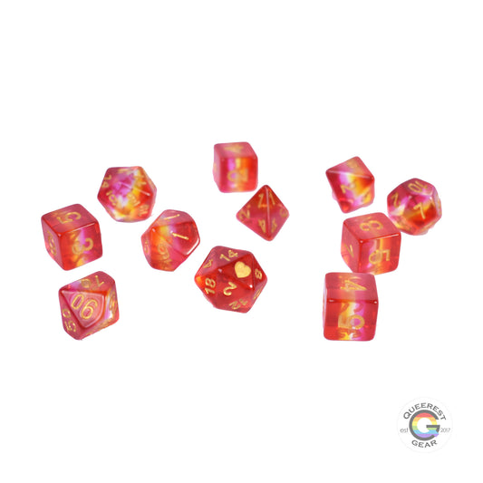 11 piece set of polyhedral dice scattered on a white background. They are transparent and colored in the stripes of the lesbian flag with gold ink.