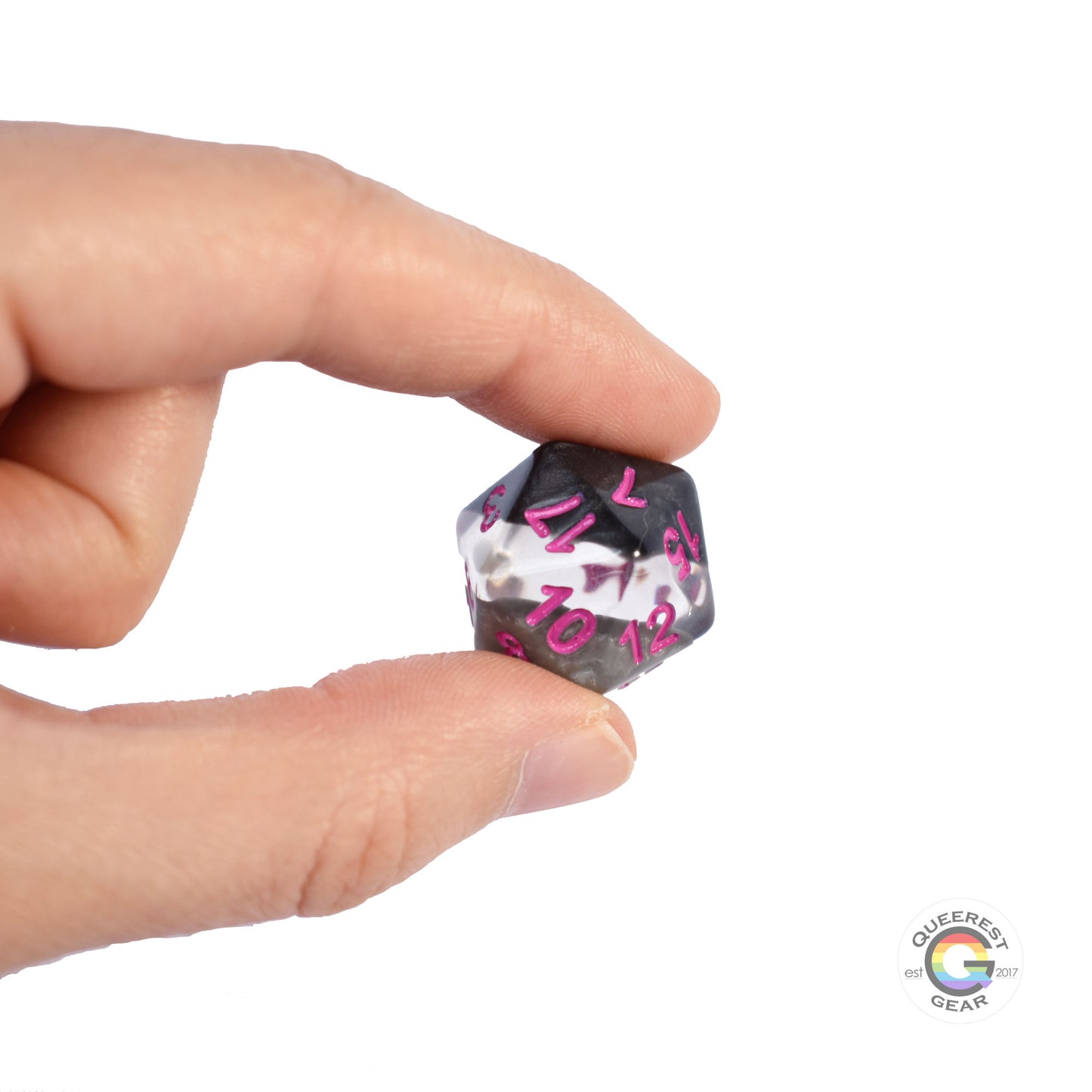 A hand holding up the demisexual d20 to show off the color and transparency