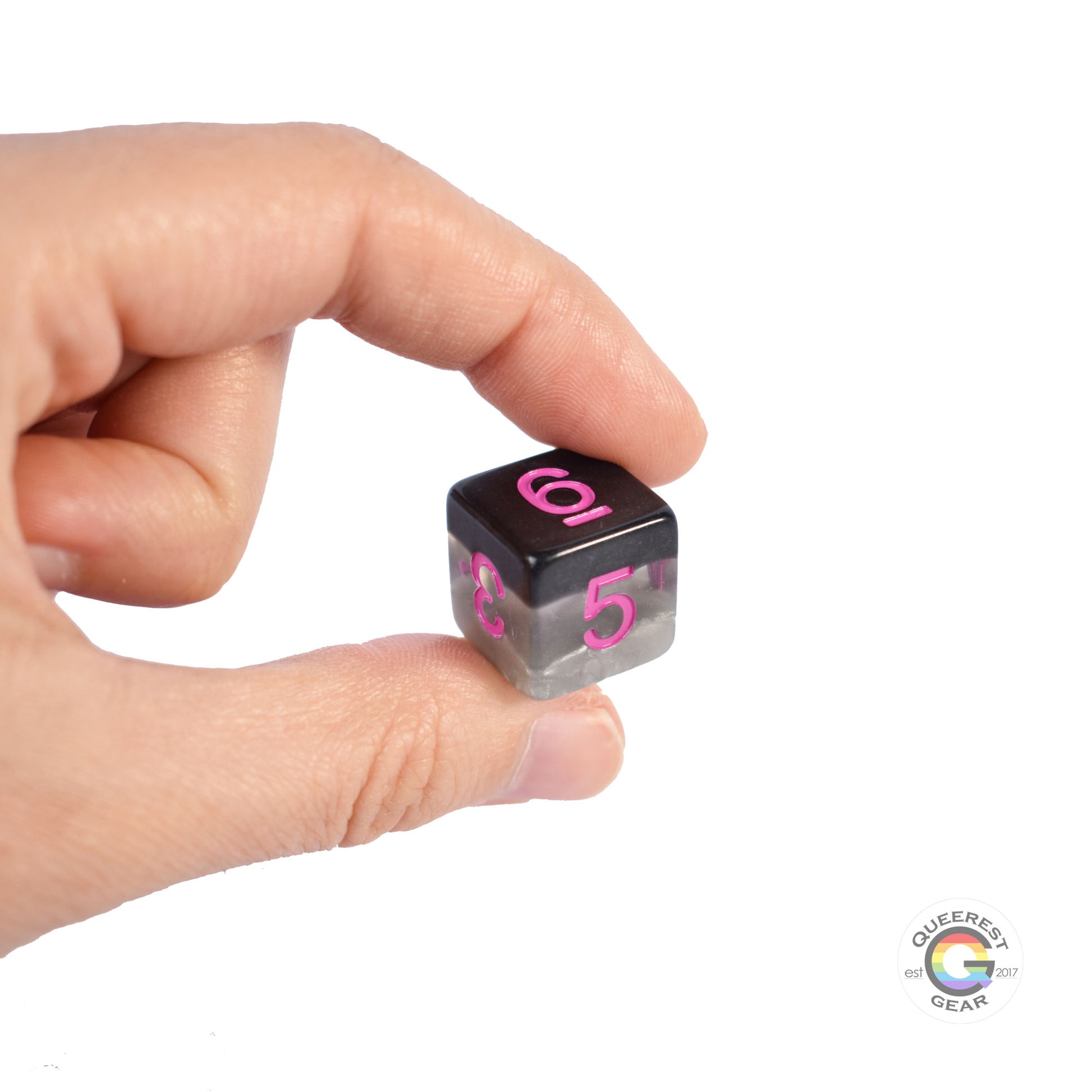 A hand holding up the demisexual d6 to show off the color and transparency