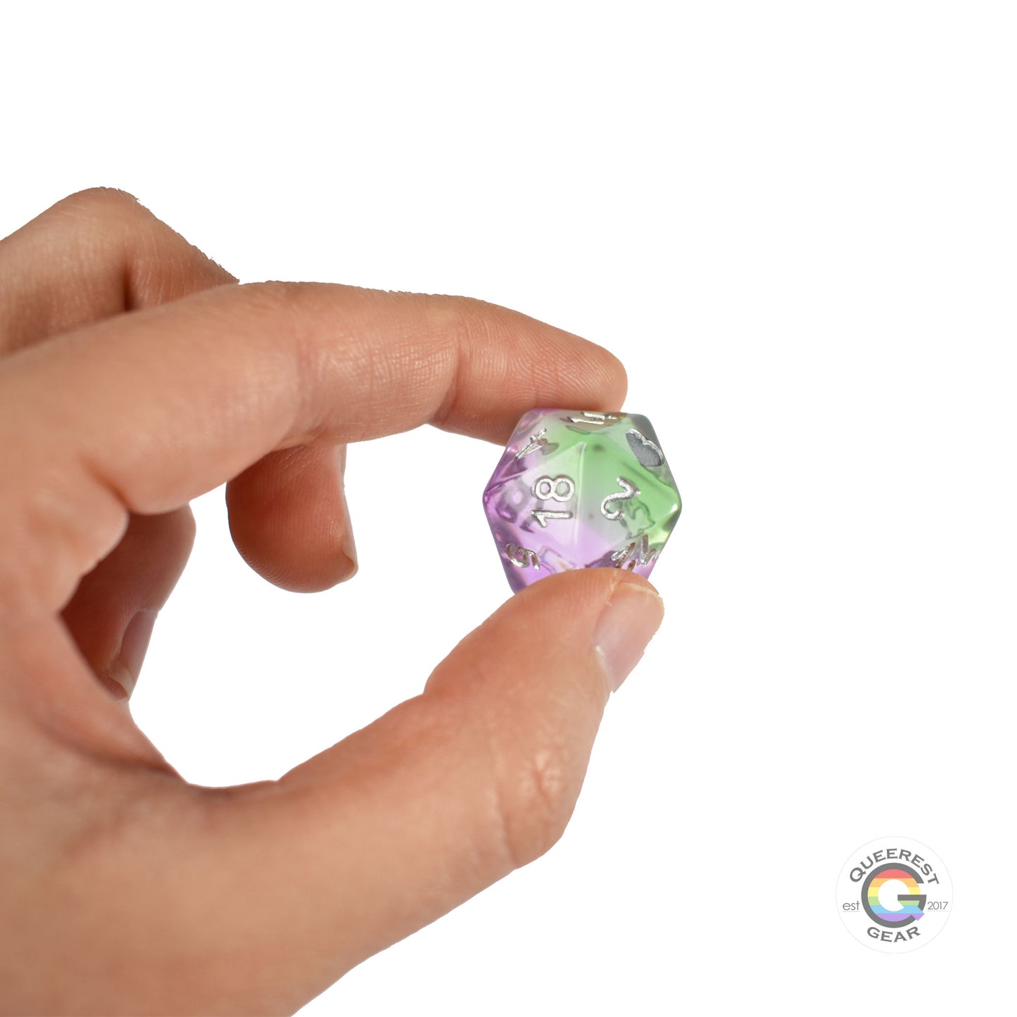 A hand holding up the genderqueer d20 to show off the color and transparency