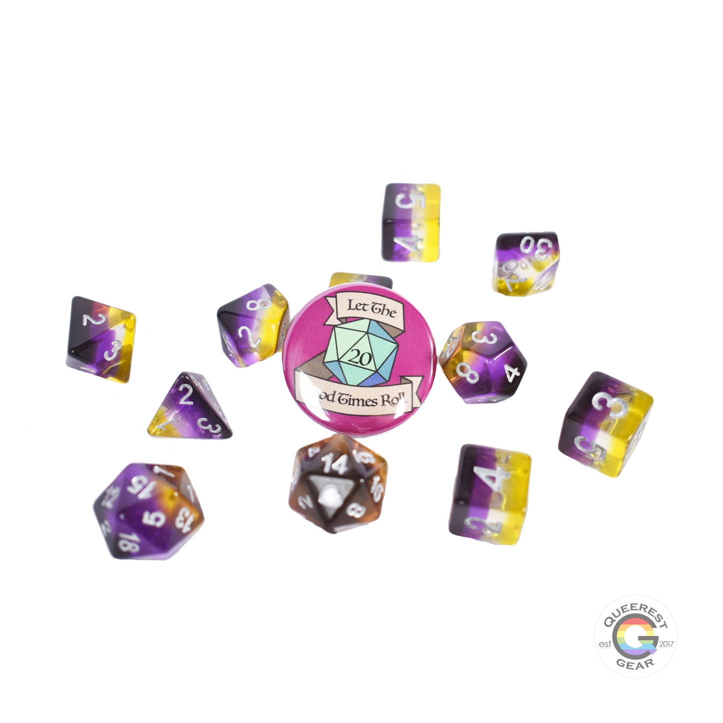 11 piece set of polyhedral dice scattered on a white background. They are transparent and colored in the stripes of the nonbinary flag with silver ink. There is the freebie “let the good times roll” pinback button among them. 