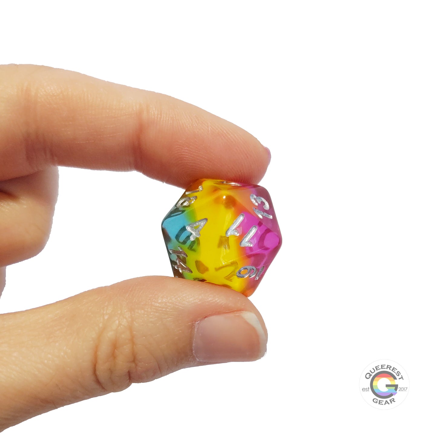 A hand holding up the pansexual  d20 to show off the color and transparency