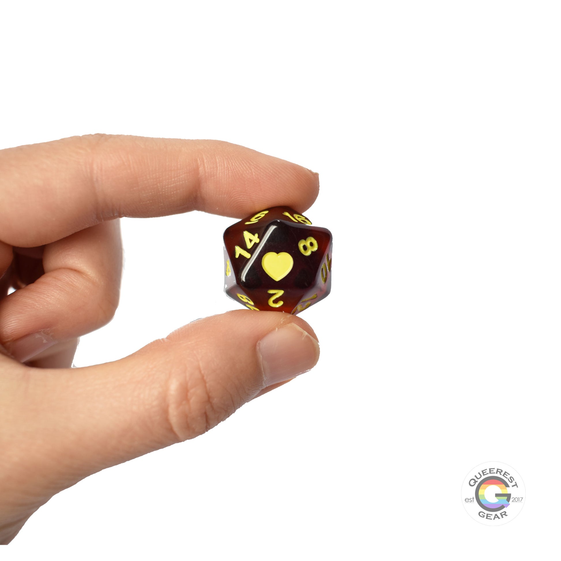 A hand holding up the polyamory d20 to show off the color, heart, and transparency