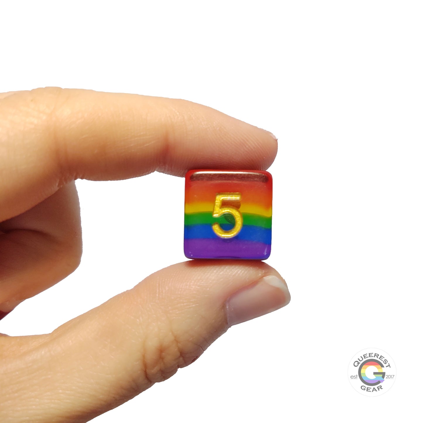  A hand holding up the rainbow d6 to show off the color and transparency