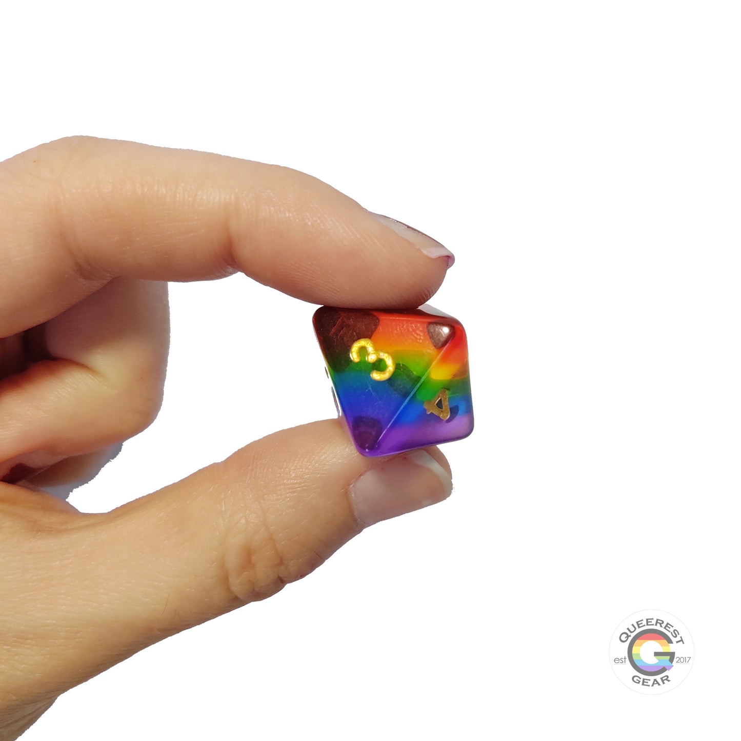  A hand holding up the rainbow d8 to show off the color and transparency