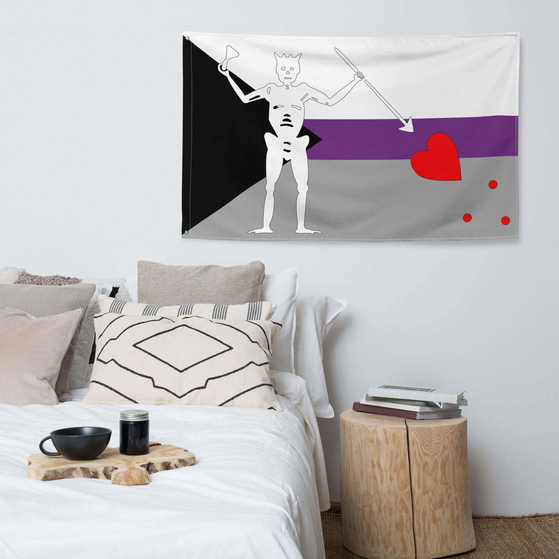 the demisexual blackbeard pride flag hanging on a white wall above a bed and side table