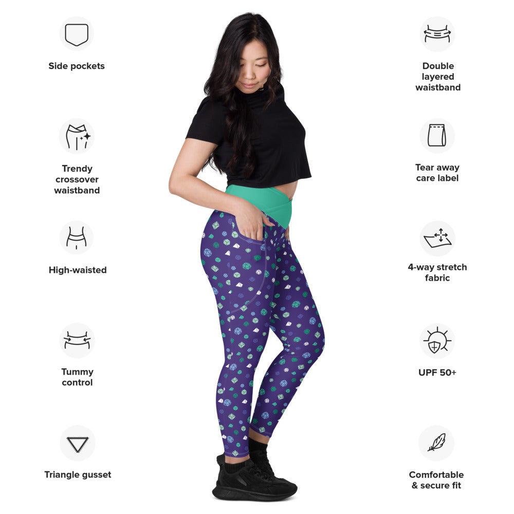 Light-skinned dark-haired female-presenting model wearing the gay mlm dice leggings. she is facing right and has a hand in the pocket. she is surrounded by product specs: "side pockets, trendy crossover waistband, high-waisted, tummy control, triangle gusset, double layered waistband, tear away care label, 4-way stretch fabric, UPF 50+, comfortable & secure fit