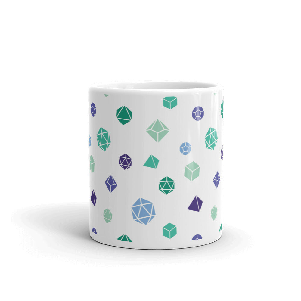 white mug on a white background with handle facing back. It has an all-over print of polyhedral d&d dice in the gay mlm colors of greens and blues