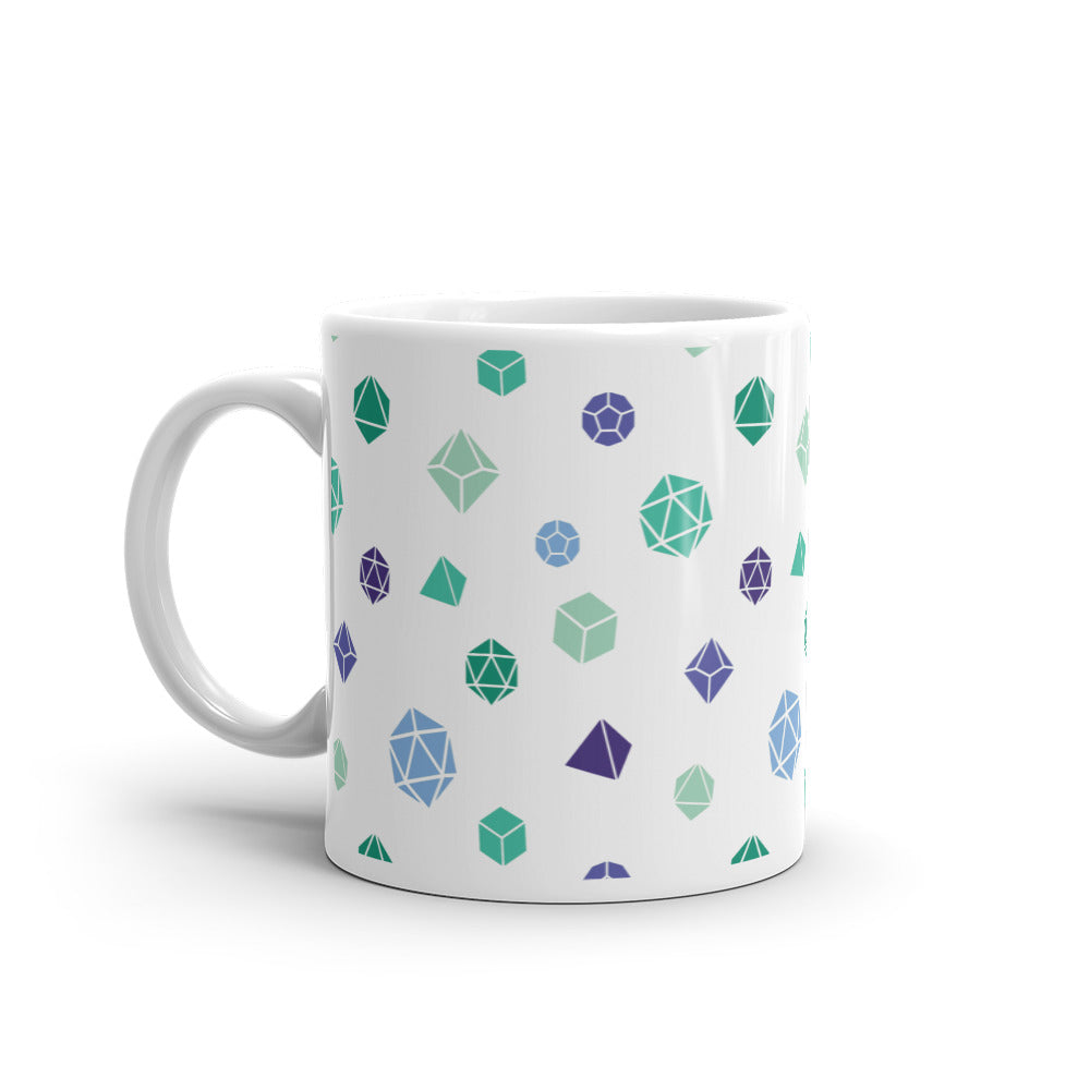 white mug on a white background with handle facing left. It has an all-over print of polyhedral d&d dice in the gay mlm colors of greens and blues