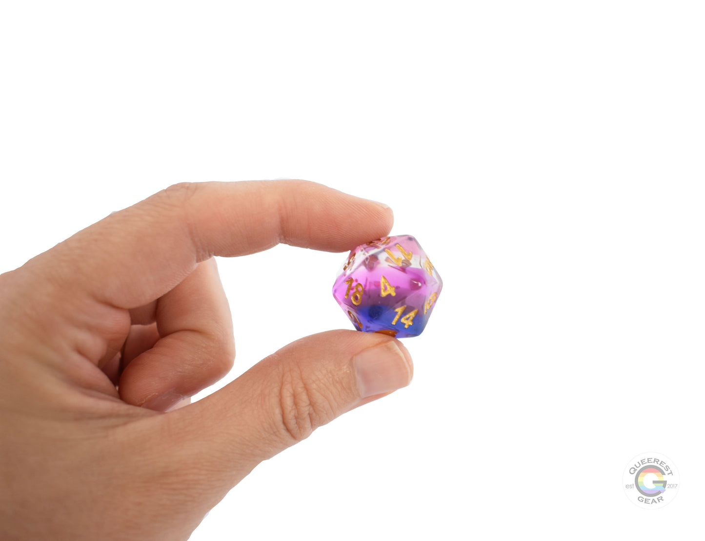 A hand holding up the genderfluid d20 to show off the color and transparency